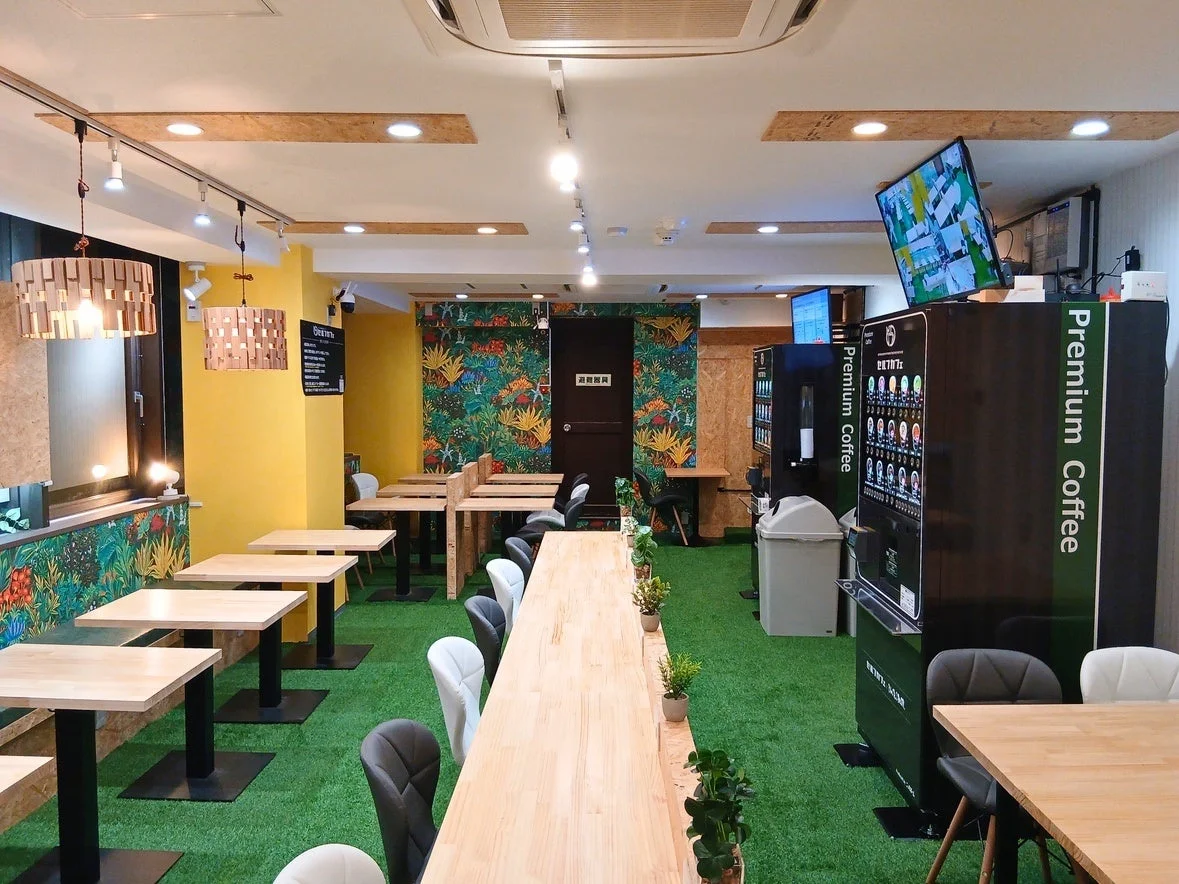 熱帯植物柄の壁紙と人工芝のカフェ