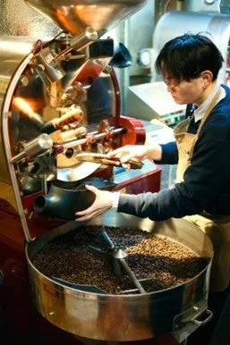 コーヒー焙煎機で、男性が丁寧にコーヒー豆を焙煎している様子