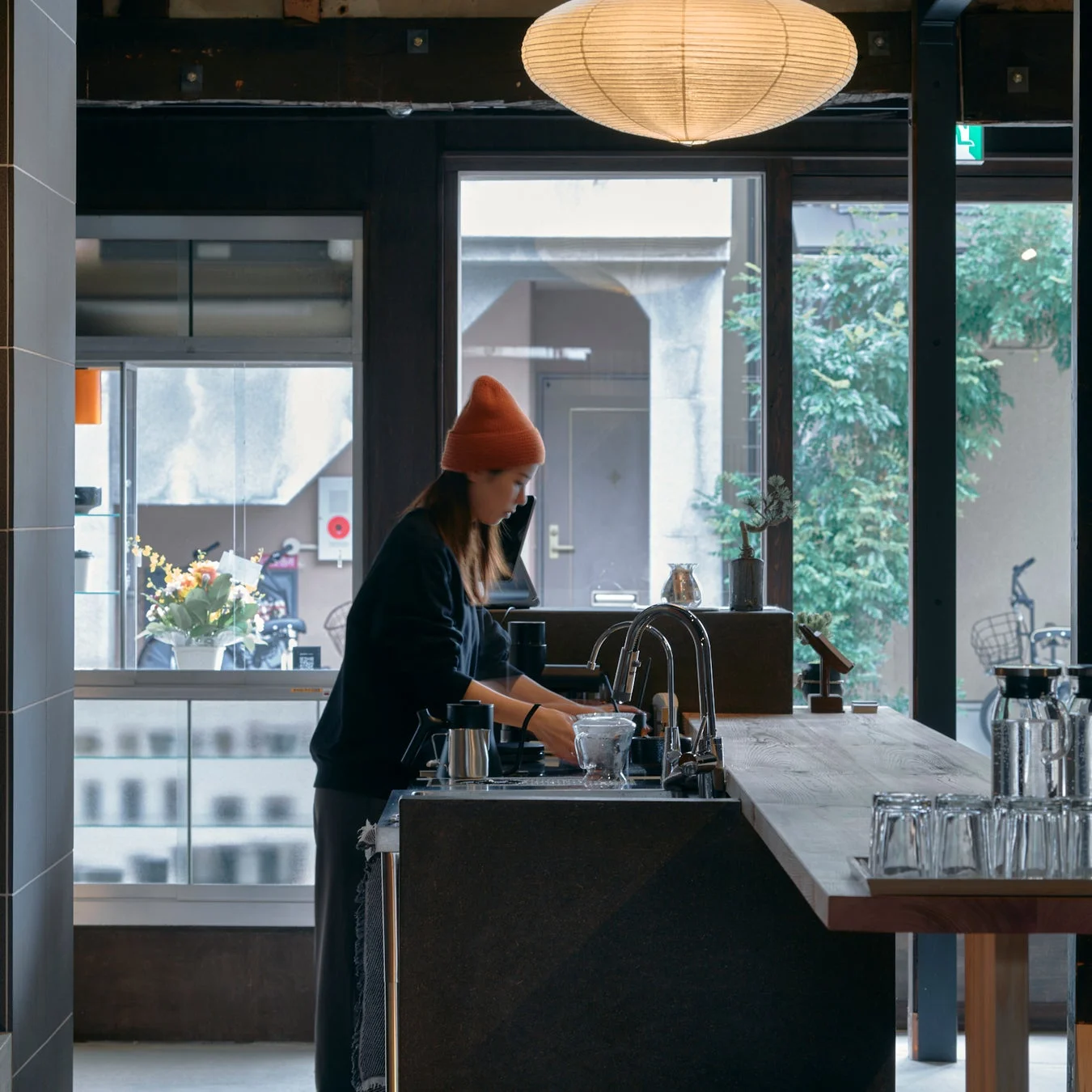 落ち着いた雰囲気のカフェカウンターで作業する女性