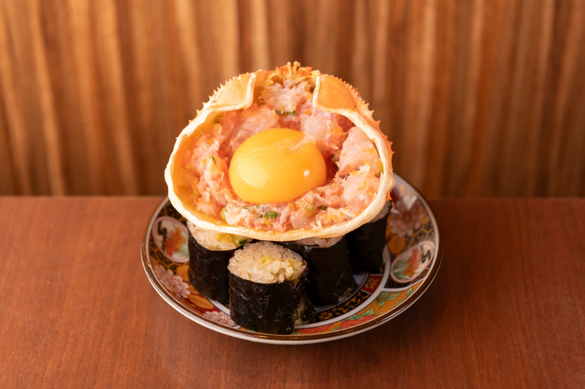 蟹の甲羅に盛り付けられたカニ肉と卵黄のあて巻き