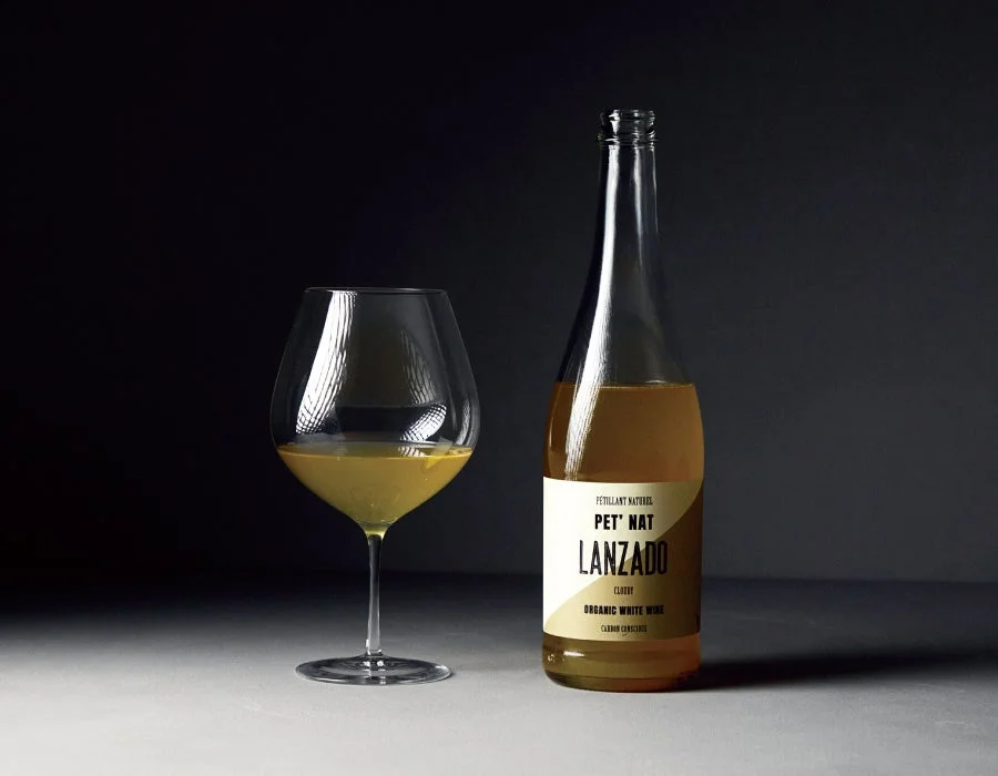 暗い背景を背に、ワイングラスとワインボトルが並べられています