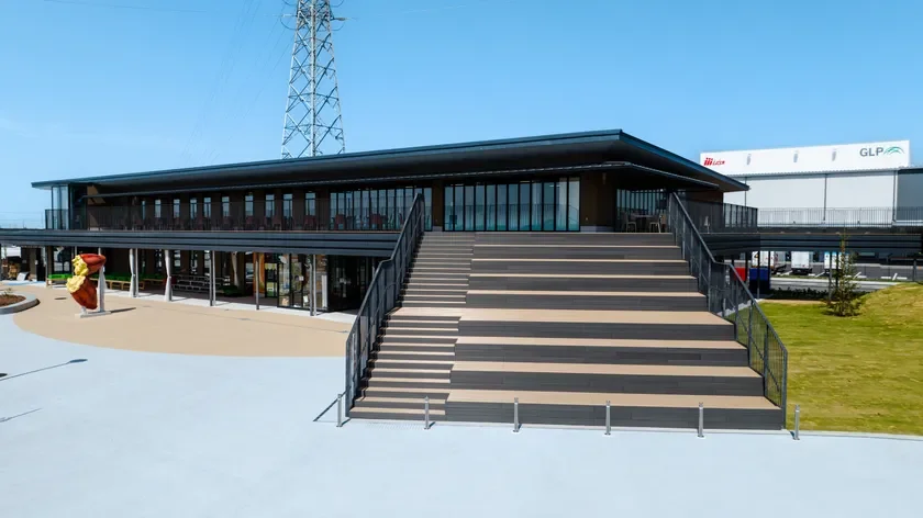 開放的な広場と大きな階段が特徴のモダンな2階建て施設