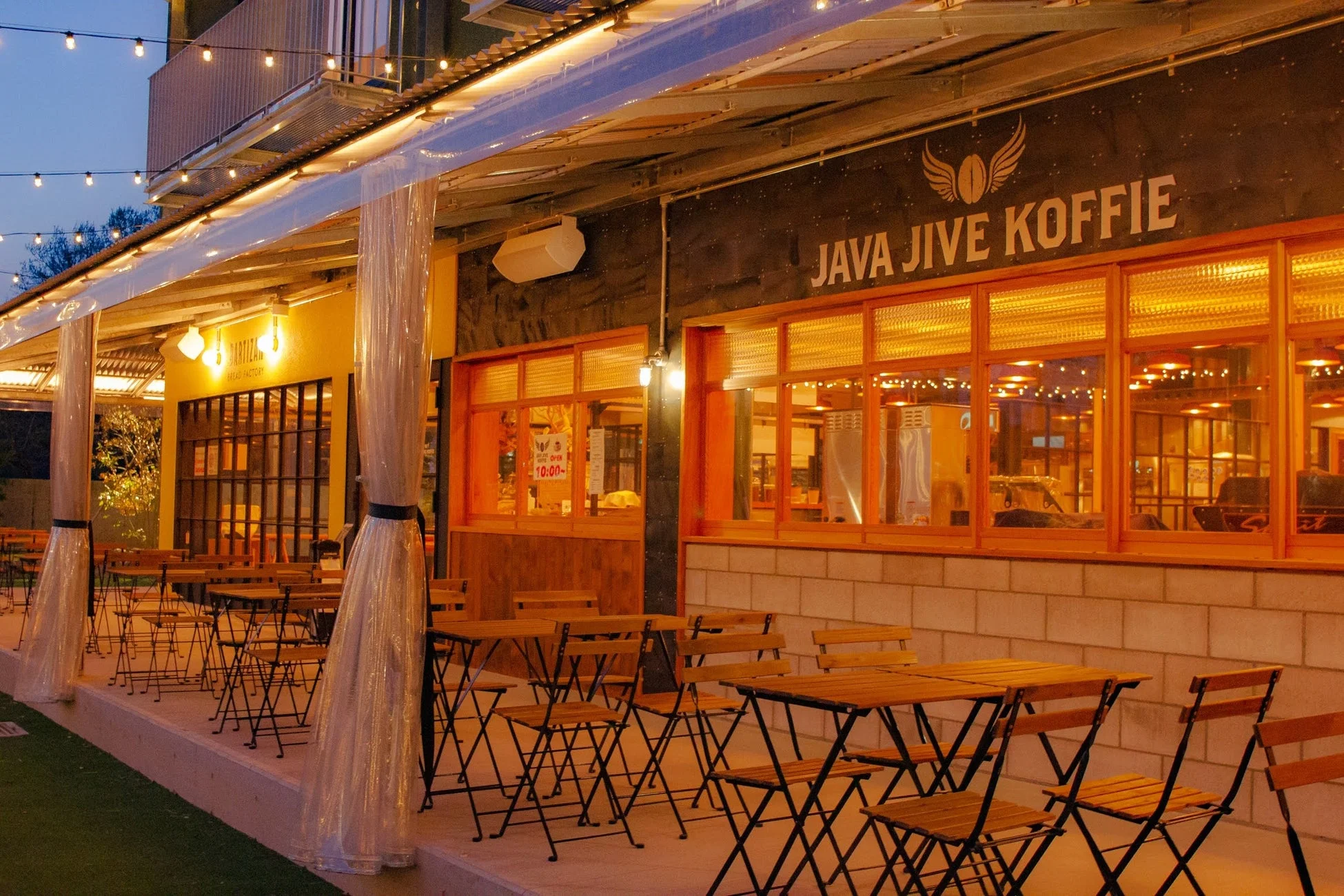 夜のカフェテラス席が並ぶ店舗の外観。