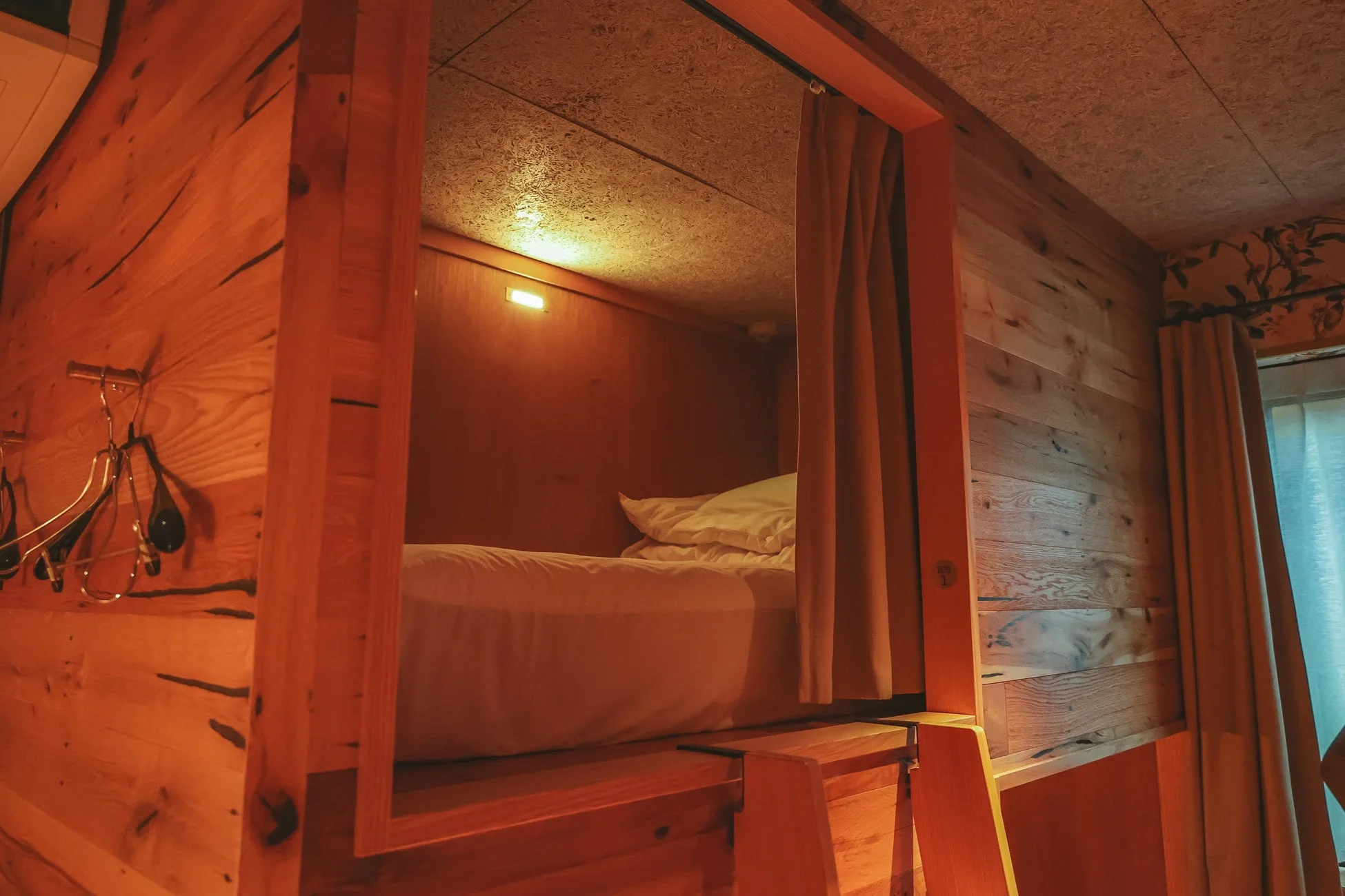 温かみのある木製の二段ベッドまたはカプセルホテルのような宿泊スペースです。
