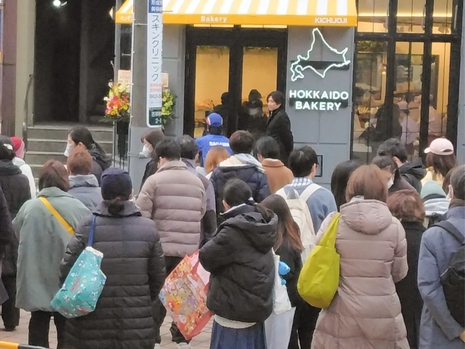 吉祥寺の街角で、多くの人々が「HOKKAIDO BAKERY」の前に列をなしている様子