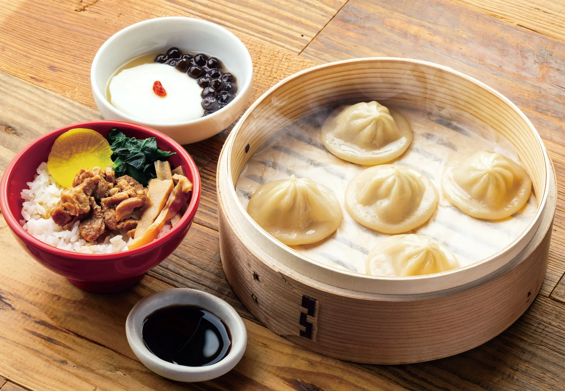 蒸篭に入った小籠包、滷肉飯（ルーローハン）らしきご飯物、そしてタピオカとクコの実が添えられた杏仁豆腐のようなデザート