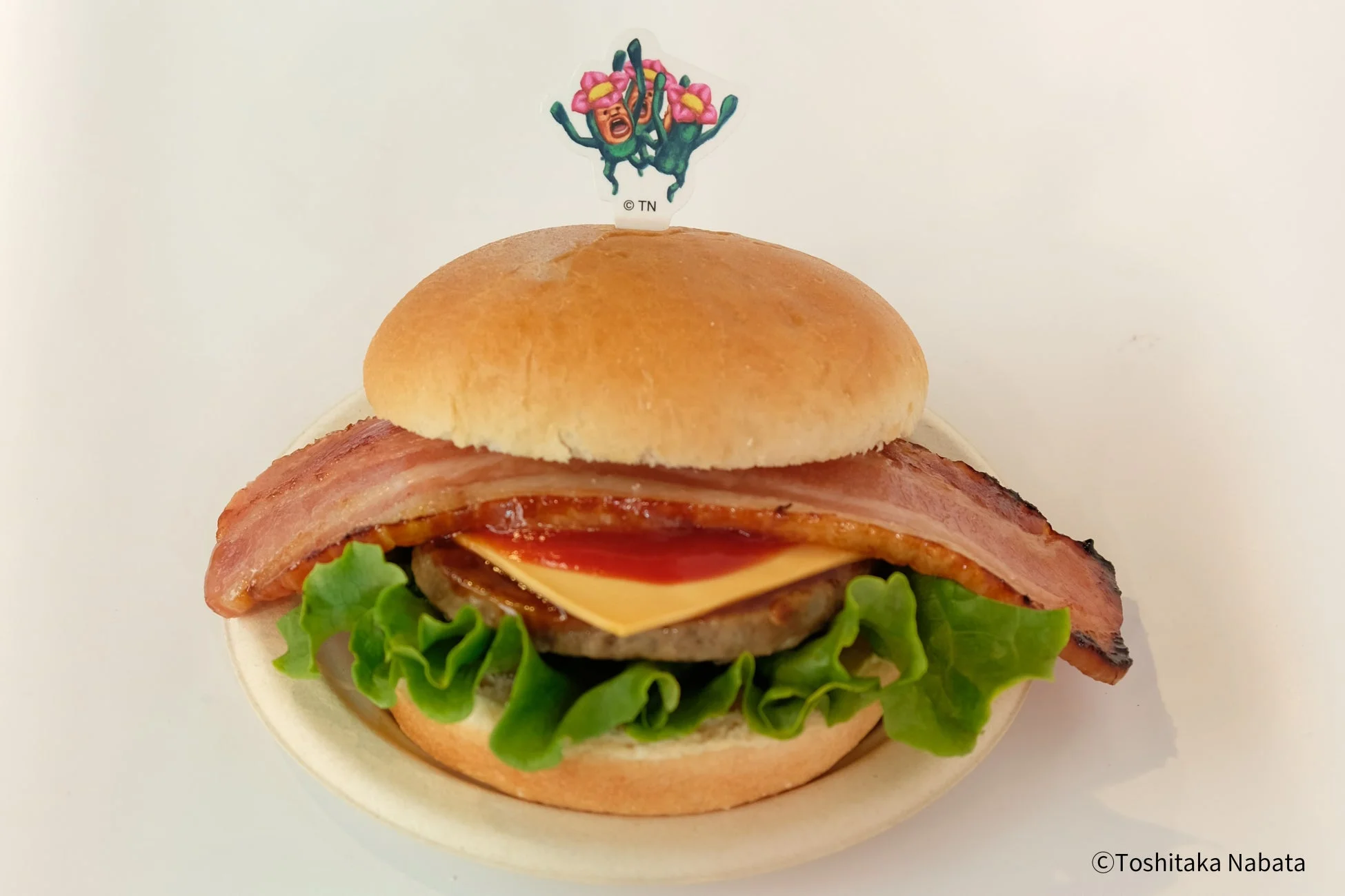 ベーコンチーズバーガーにキャラクターピックが刺さったコラボメニュー
