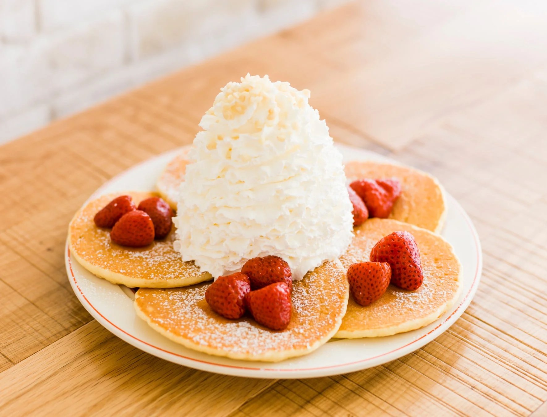ホイップクリームといちごが添えられたパンケーキ