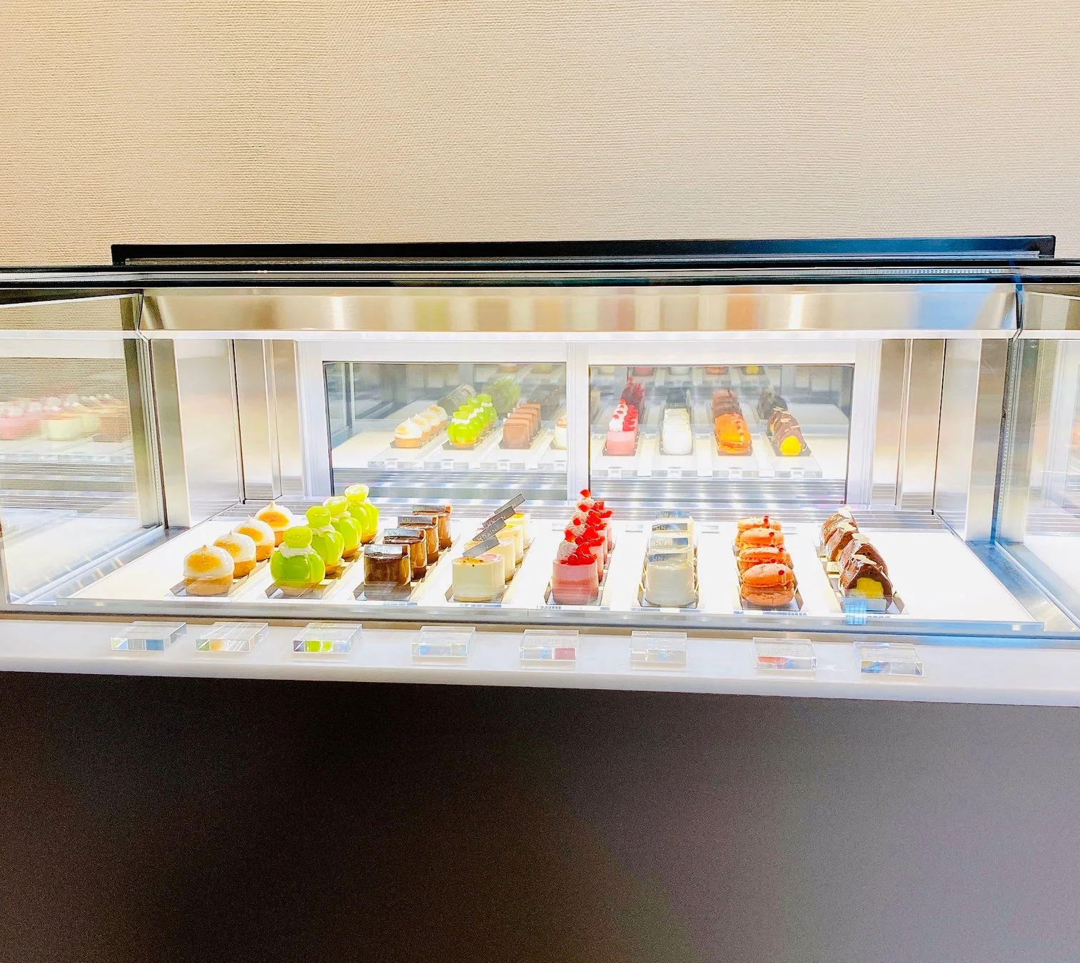 明るい照明が当たるショーケースに、色とりどりの美しい洋菓子が多数並んでいます。