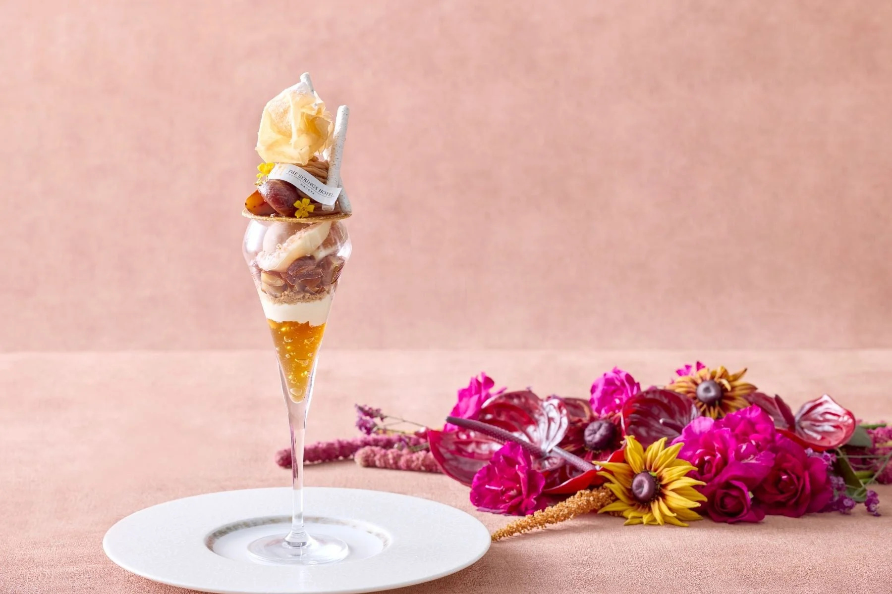 ピンクや黄色の花々が美しく配置されたパフェ