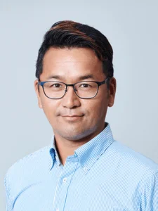 青いストライプのシャツと眼鏡をかけたアジア人男性のポートレート