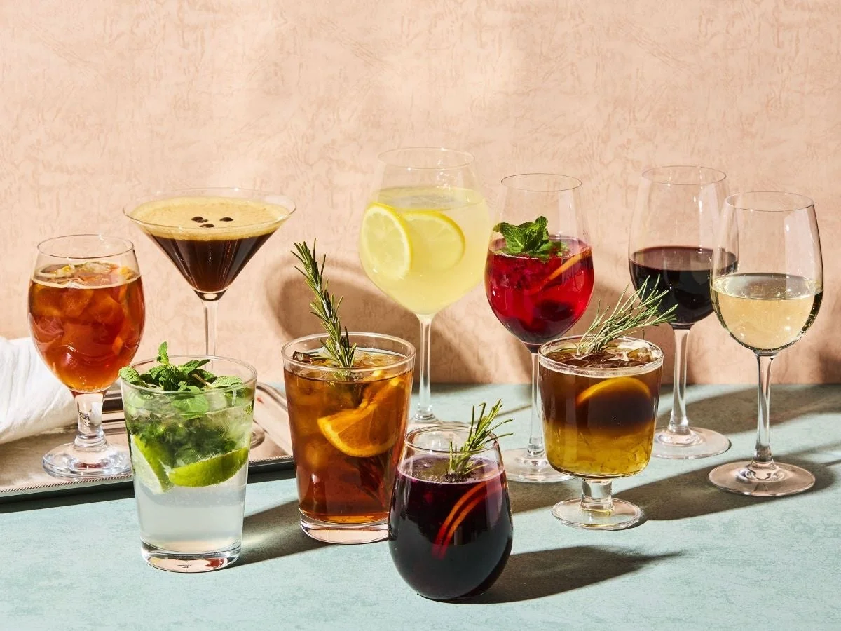 様々な種類のカクテル、ワイン、コーヒーカクテル、アイスティーなどが並べられた写真です。フルーツやハーブで美しく飾られた、色とりどりの爽やかな飲み物たちが印象的です。