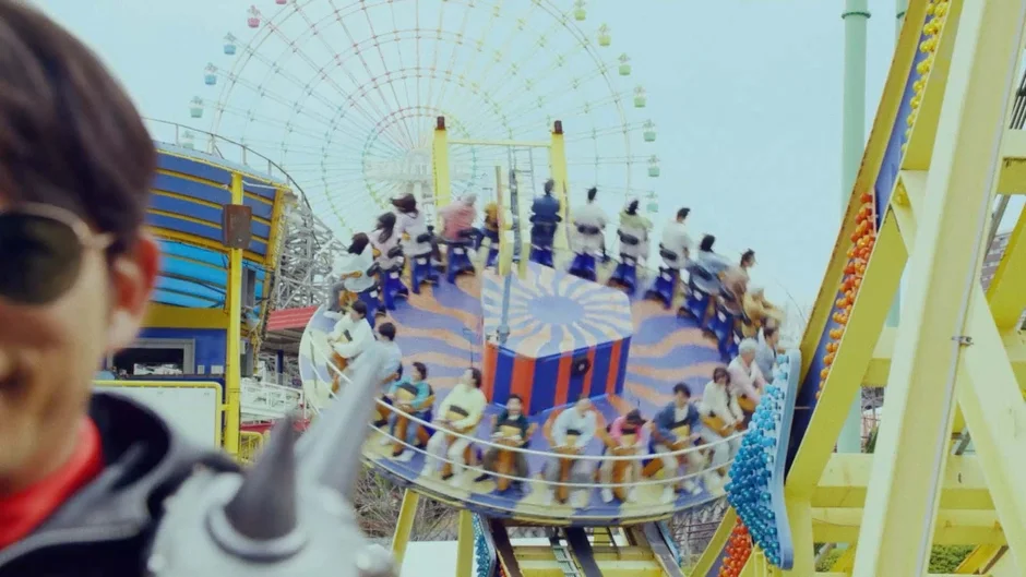 遊園地背景にサングラスの人物