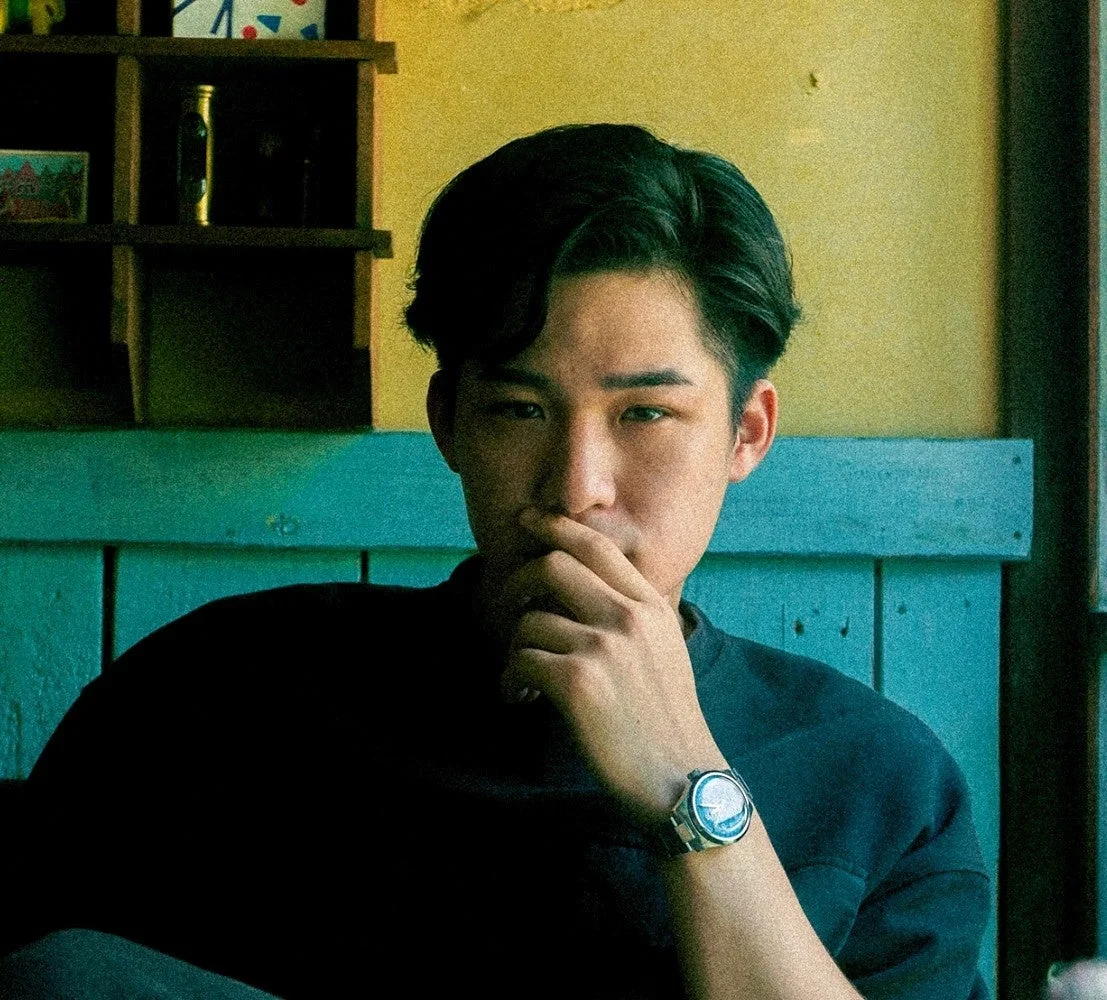 レトロな雰囲気の室内でカメラを見つめる若いアジア人男性