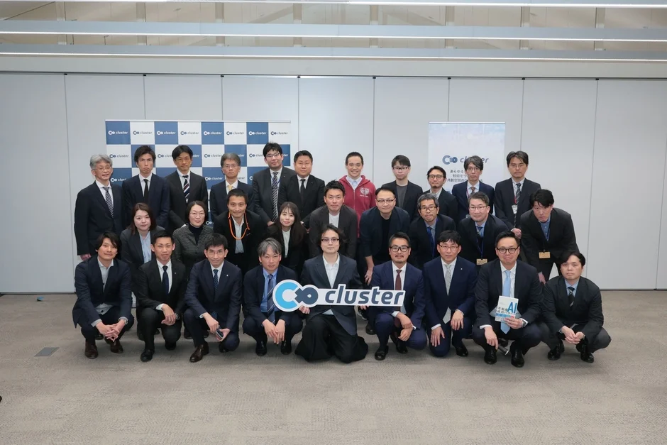 多数のビジネスパーソンが屋内会議室で集合写真を撮影している様子