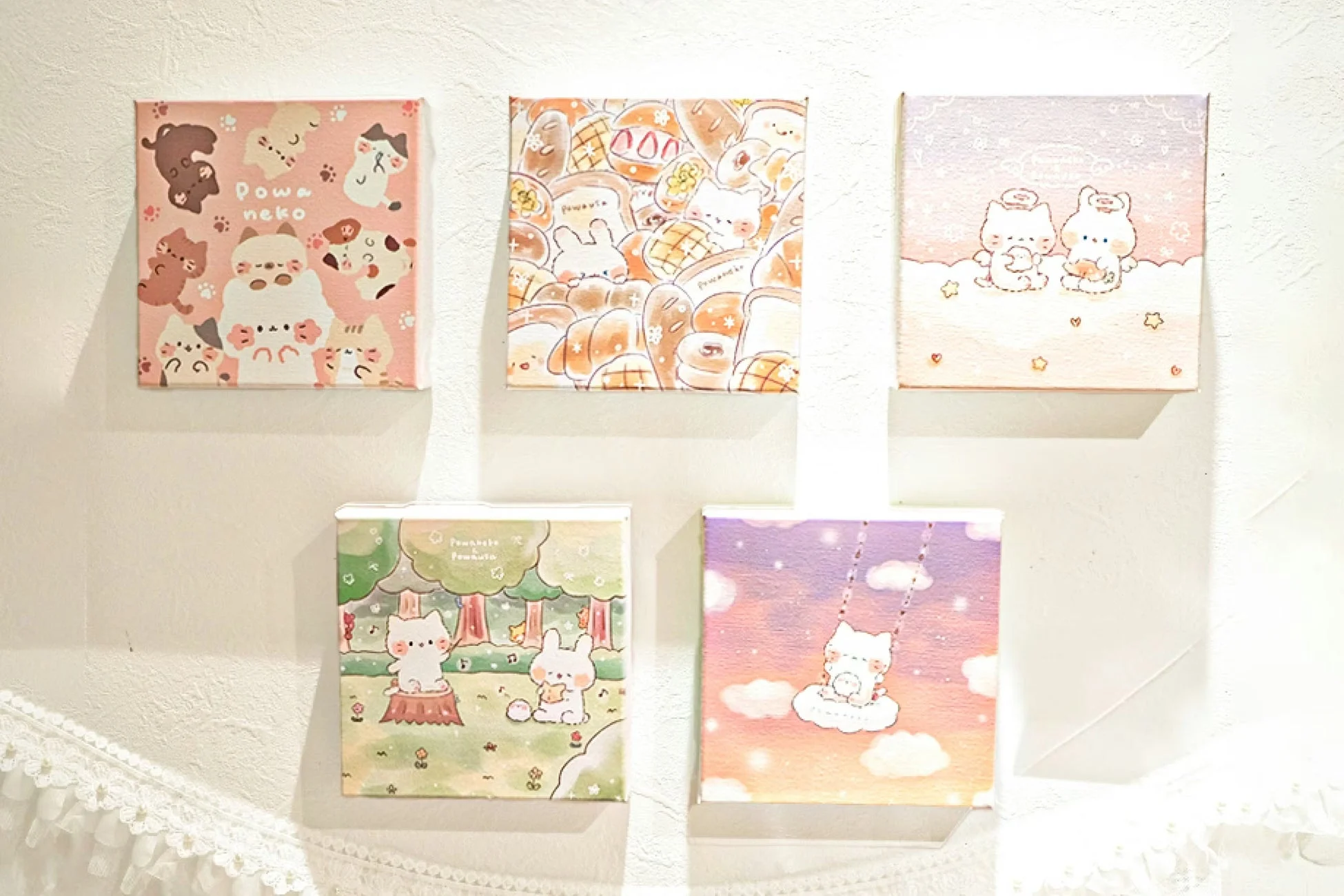 白い壁に飾られた、パステル調の可愛らしいイラストが描かれた5枚のミニキャンバス