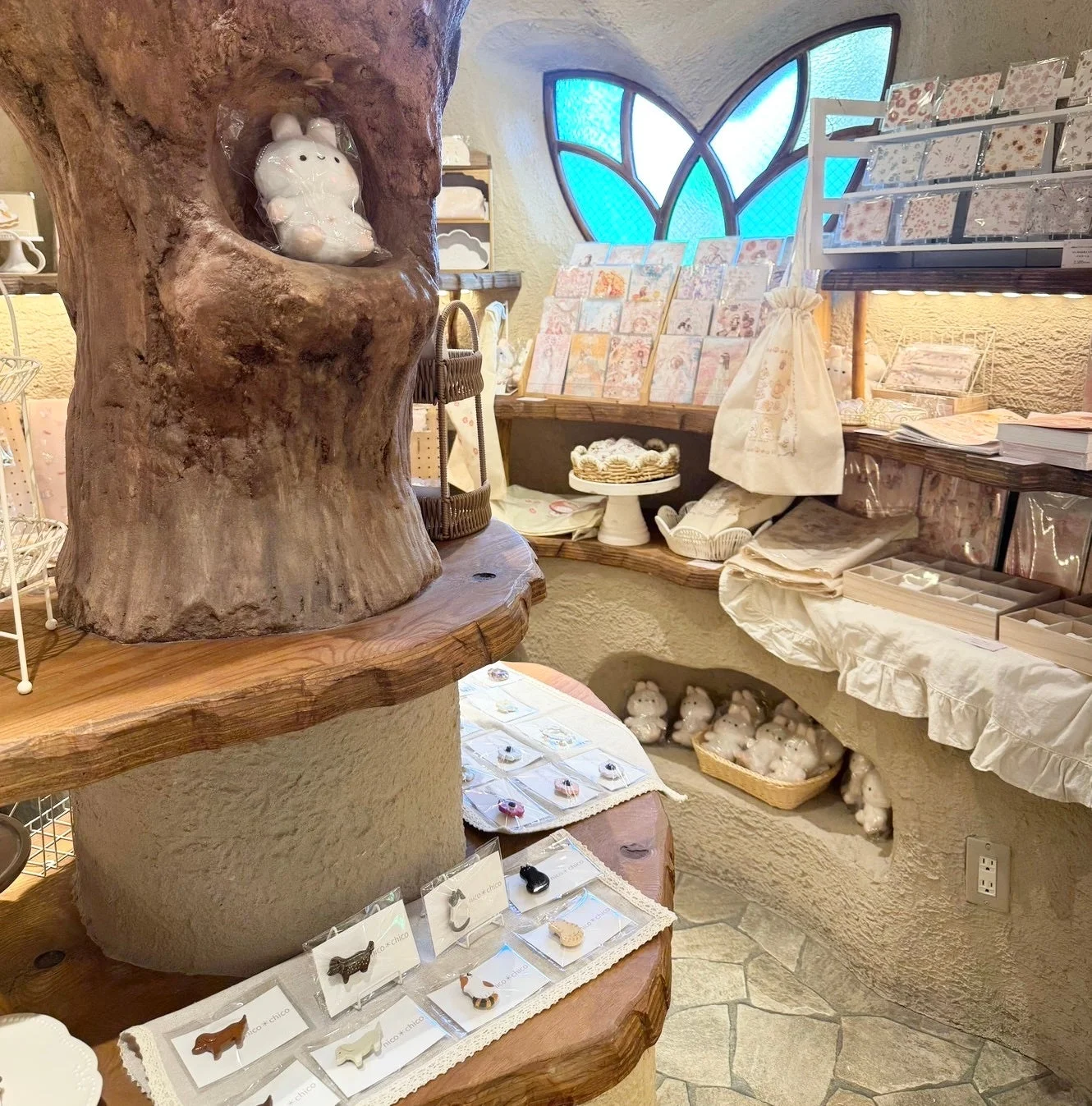 メルヘンチックな雰囲気の雑貨店で、木の幹を模したオブジェや、可愛らしいウサギの置物などが並ぶ