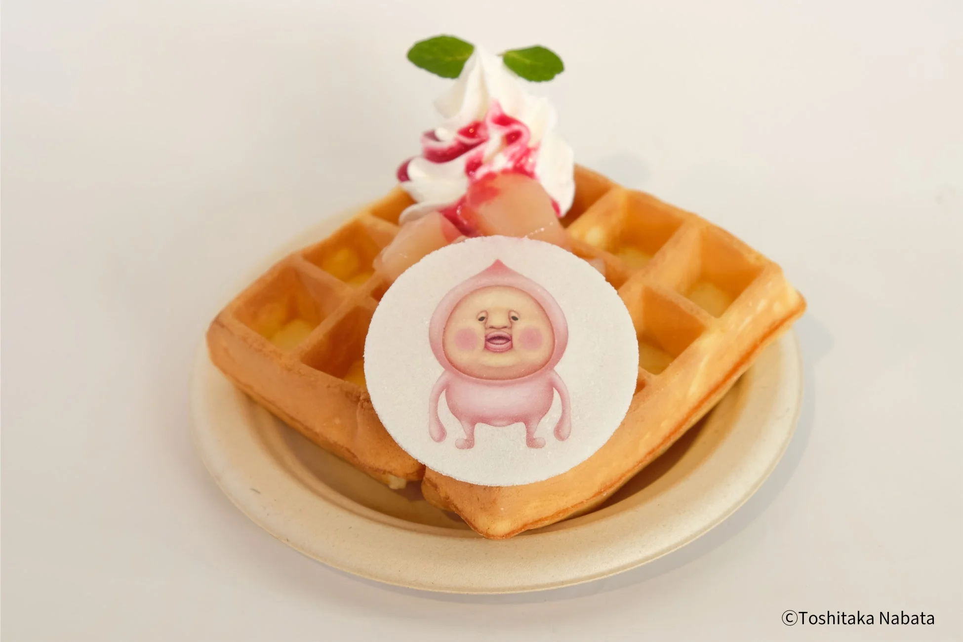 ホイップクリームと桃の果肉がトッピングされたワッフル