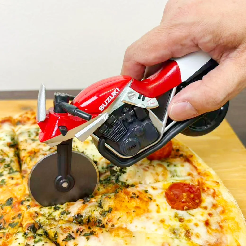 赤いピザカッターナでピザをカットする様子