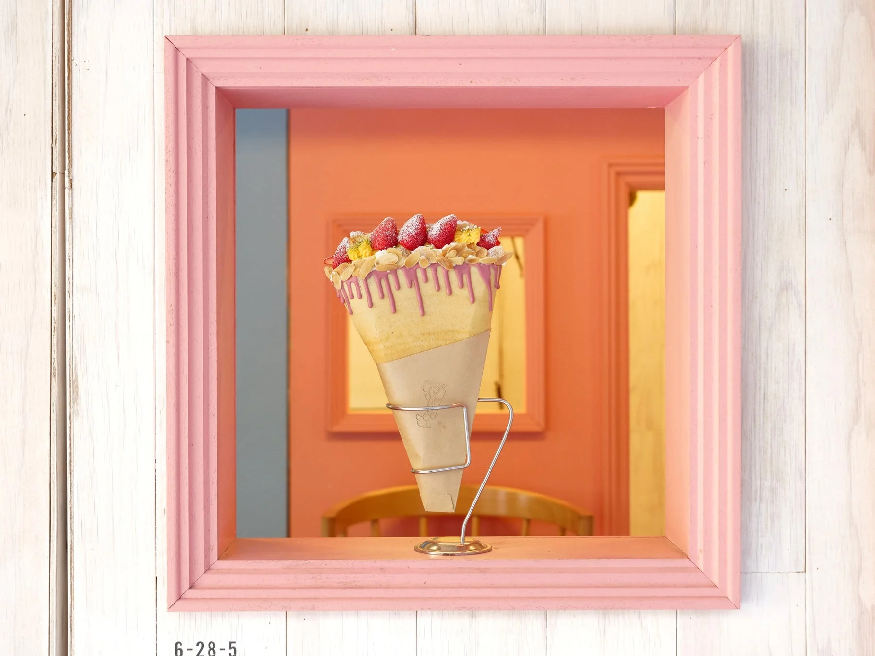 ピンクの額縁の中に飾られた限定クレープ「ナポレオンパイメルト」