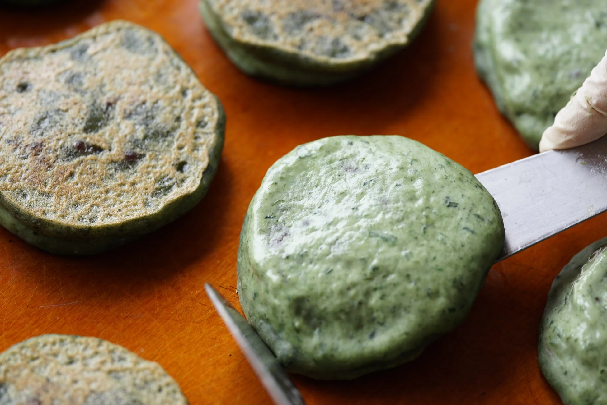 緑色の生地を調理する様子