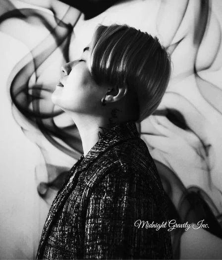 モノクロ写真で、ショートヘアの人物が目を閉じ、顔を上に向けている横顔のポートレート。