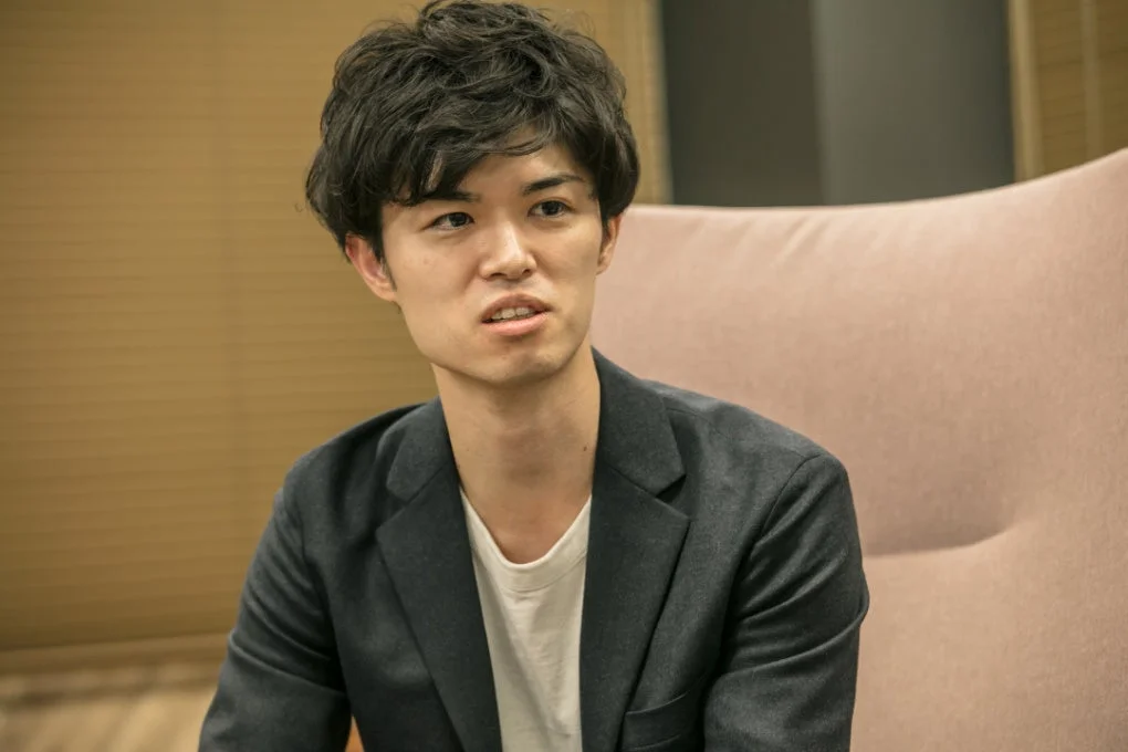 若い男性が室内で会話している様子のポートレート写真