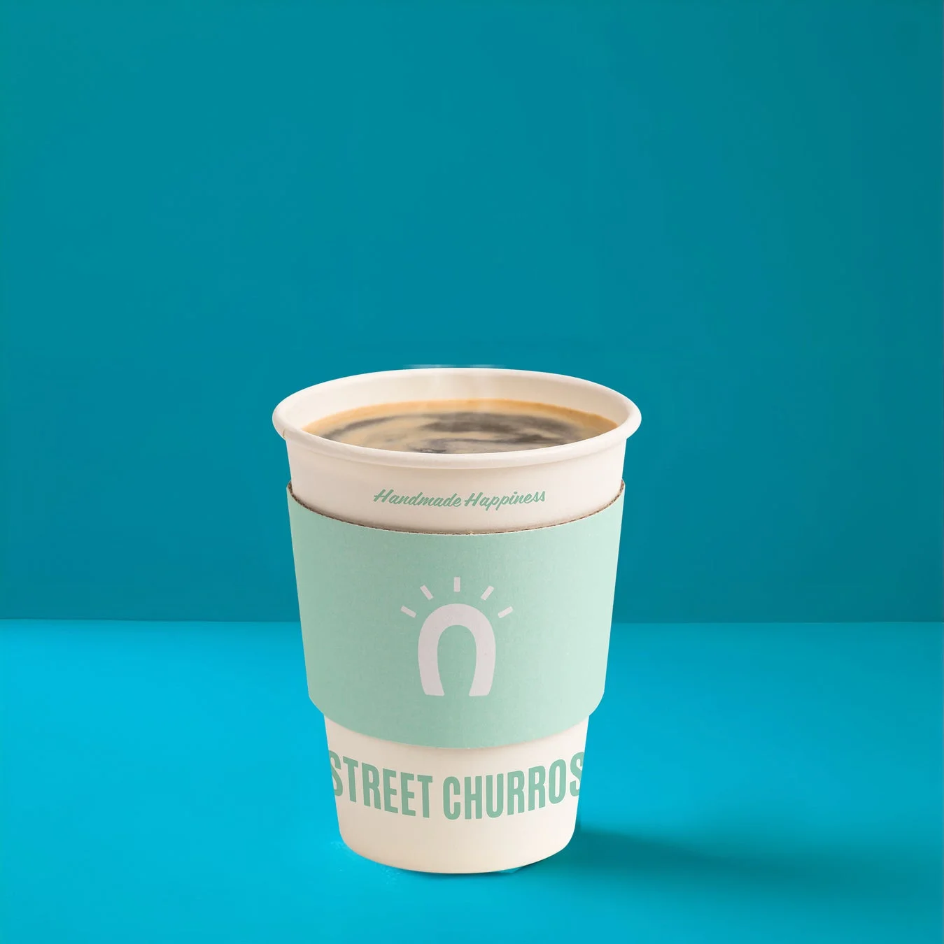 白い紙カップに入ったホットコーヒーの写真