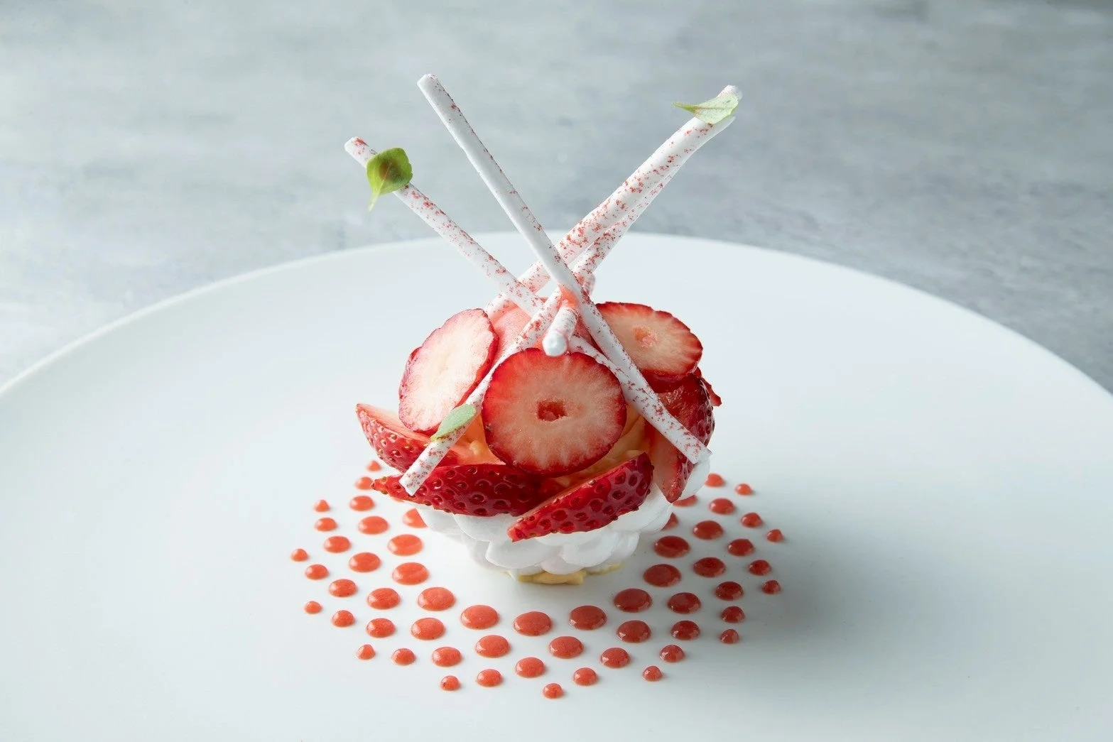 白い皿に盛り付けられたイチゴとクリームを使ったデザート