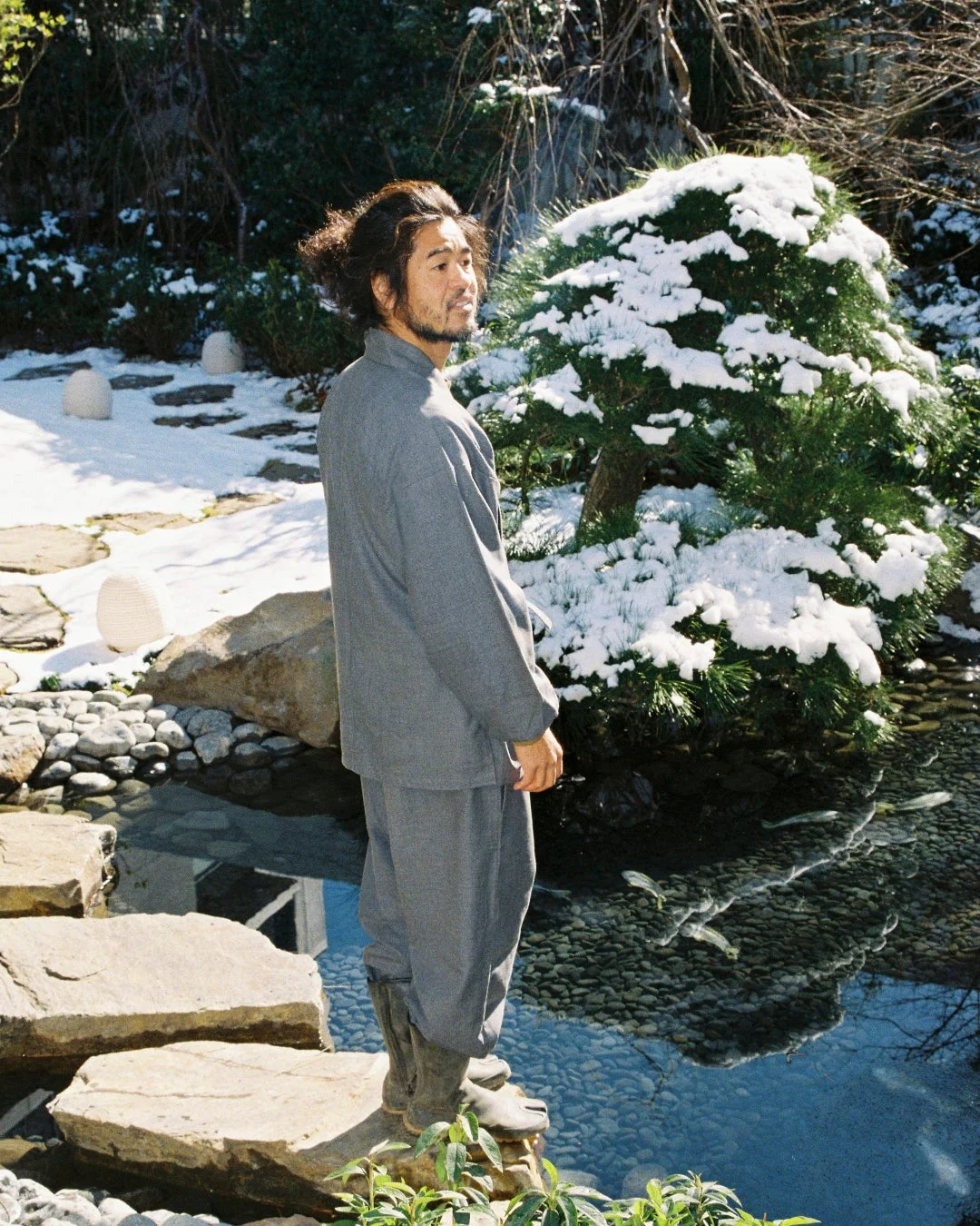 雪化粧の日本庭園に立つ男性
