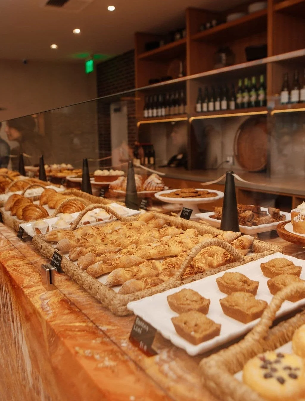様々な種類のパンや焼き菓子が美しく陳列されたベーカリーカウンター
