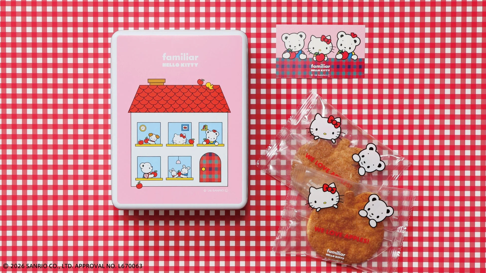 ハローキティとファミリアのコラボ商品であるりんごの形をしたクッキーが入った袋と家型のピンクの缶