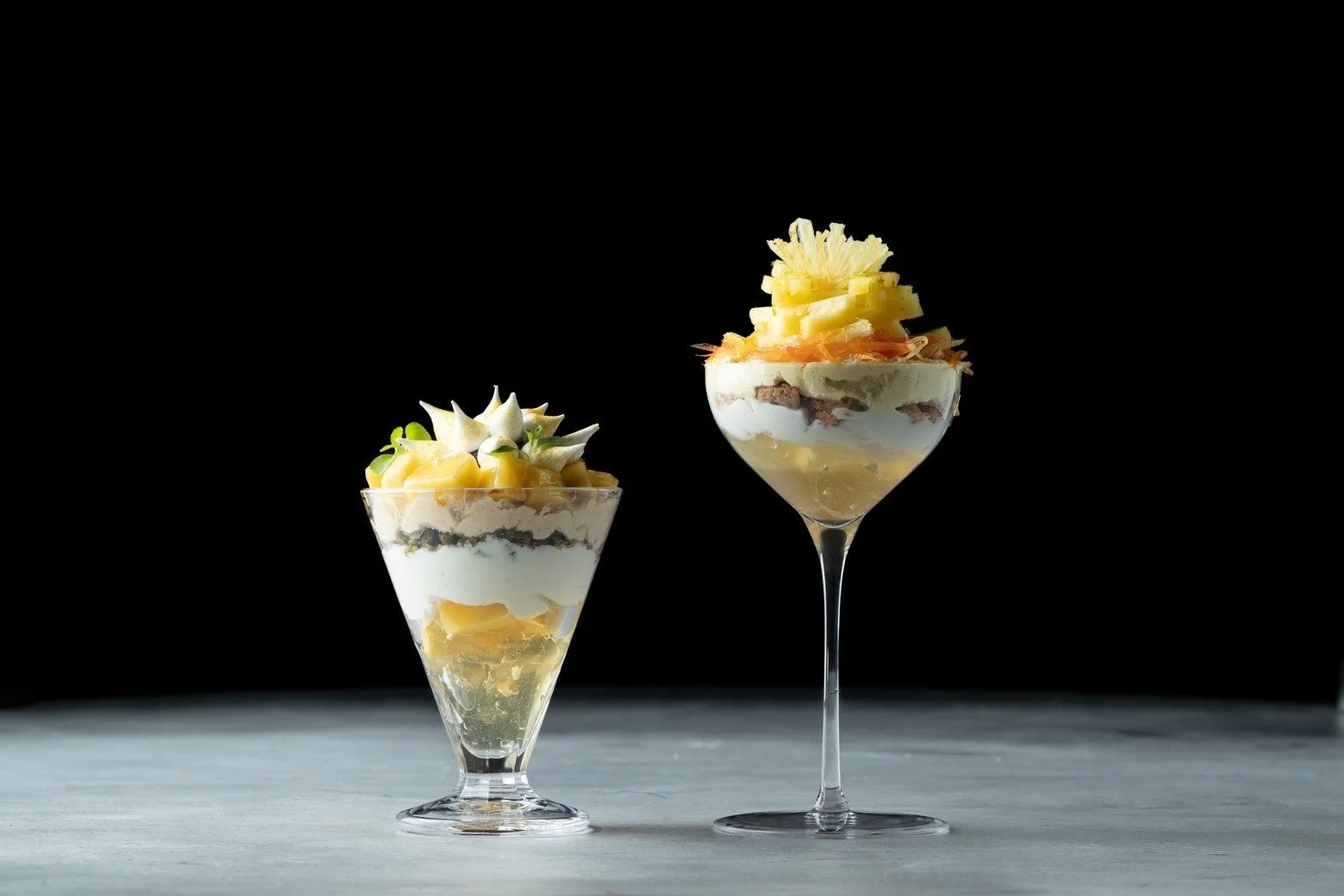 パイナップルやクリームなどが層になった2種類のグラスデザート