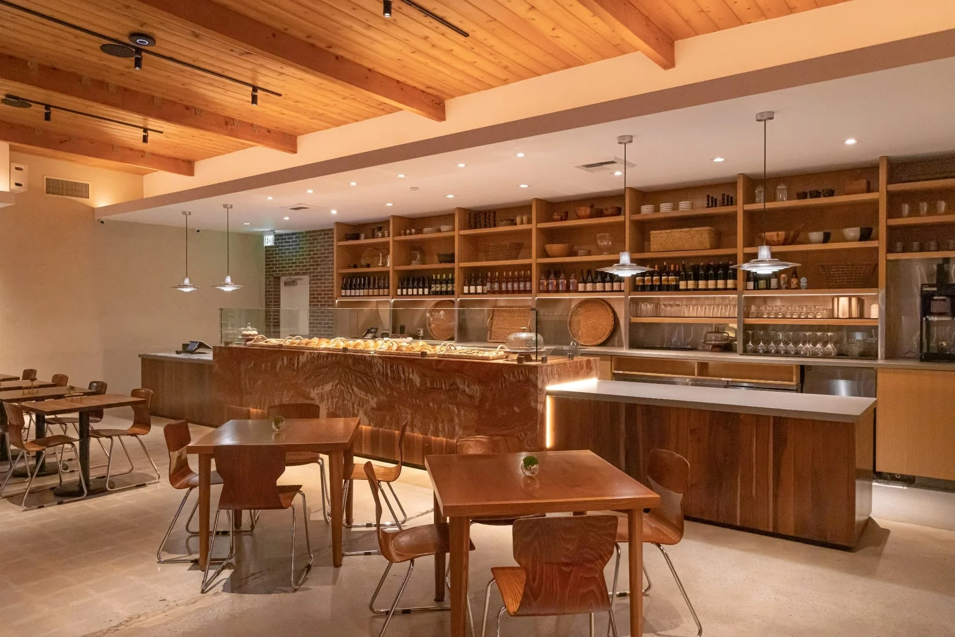 木製の天井と家具が特徴的な、モダンで落ち着いた雰囲気のカフェ店内