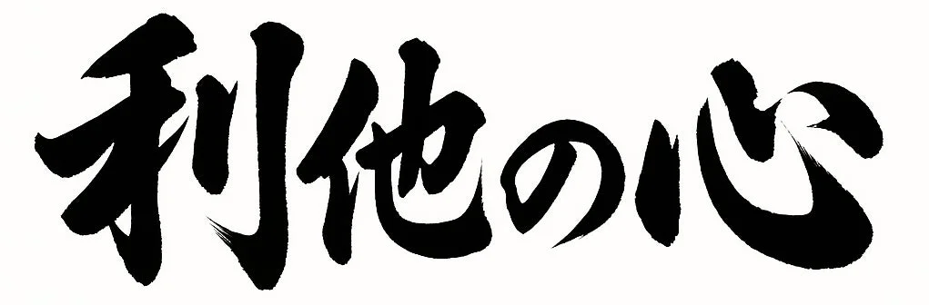 白地に黒い筆文字で「利他の心」と書かれた書道の画像です。