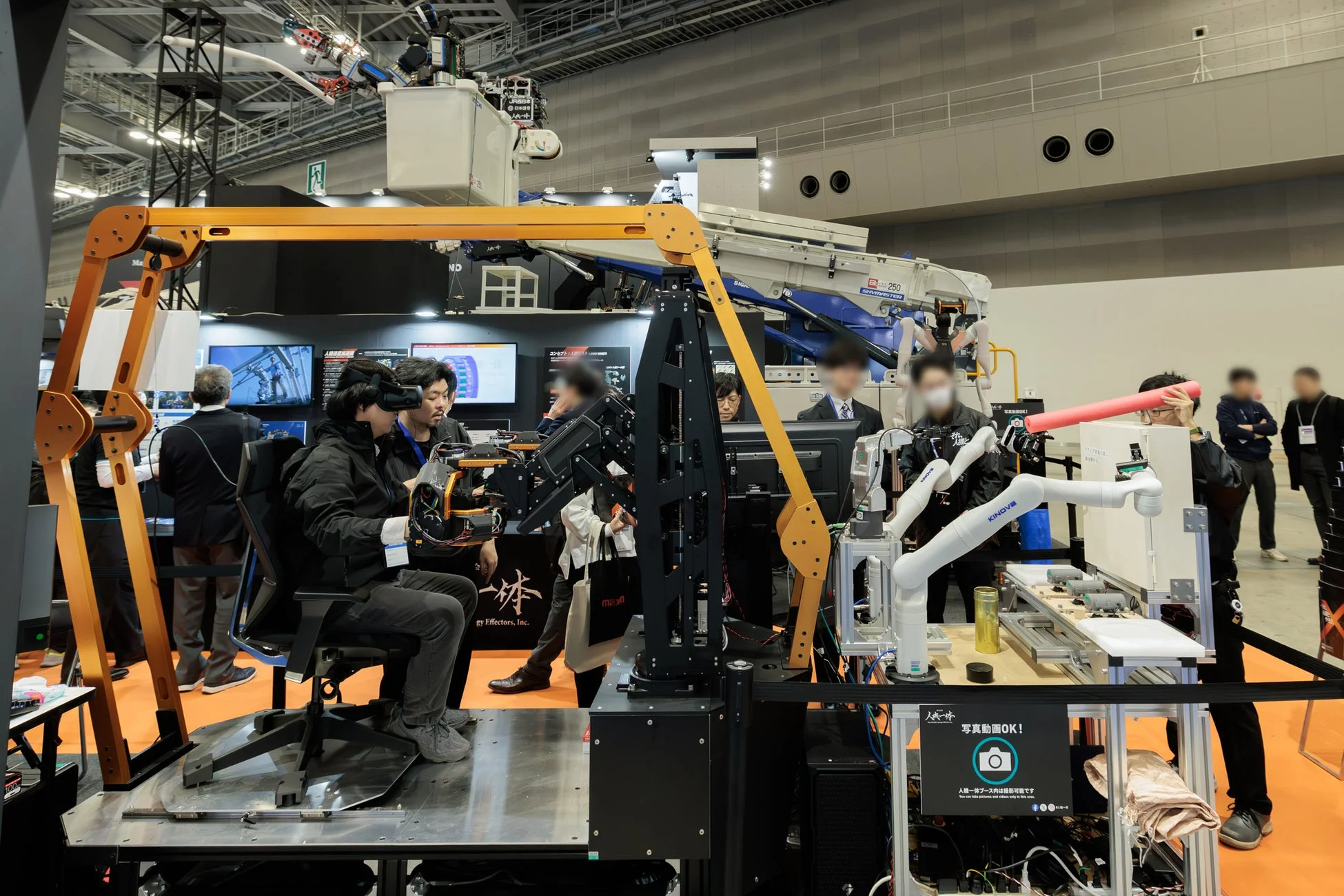 展示会でVRとロボットアームを体験する来場者