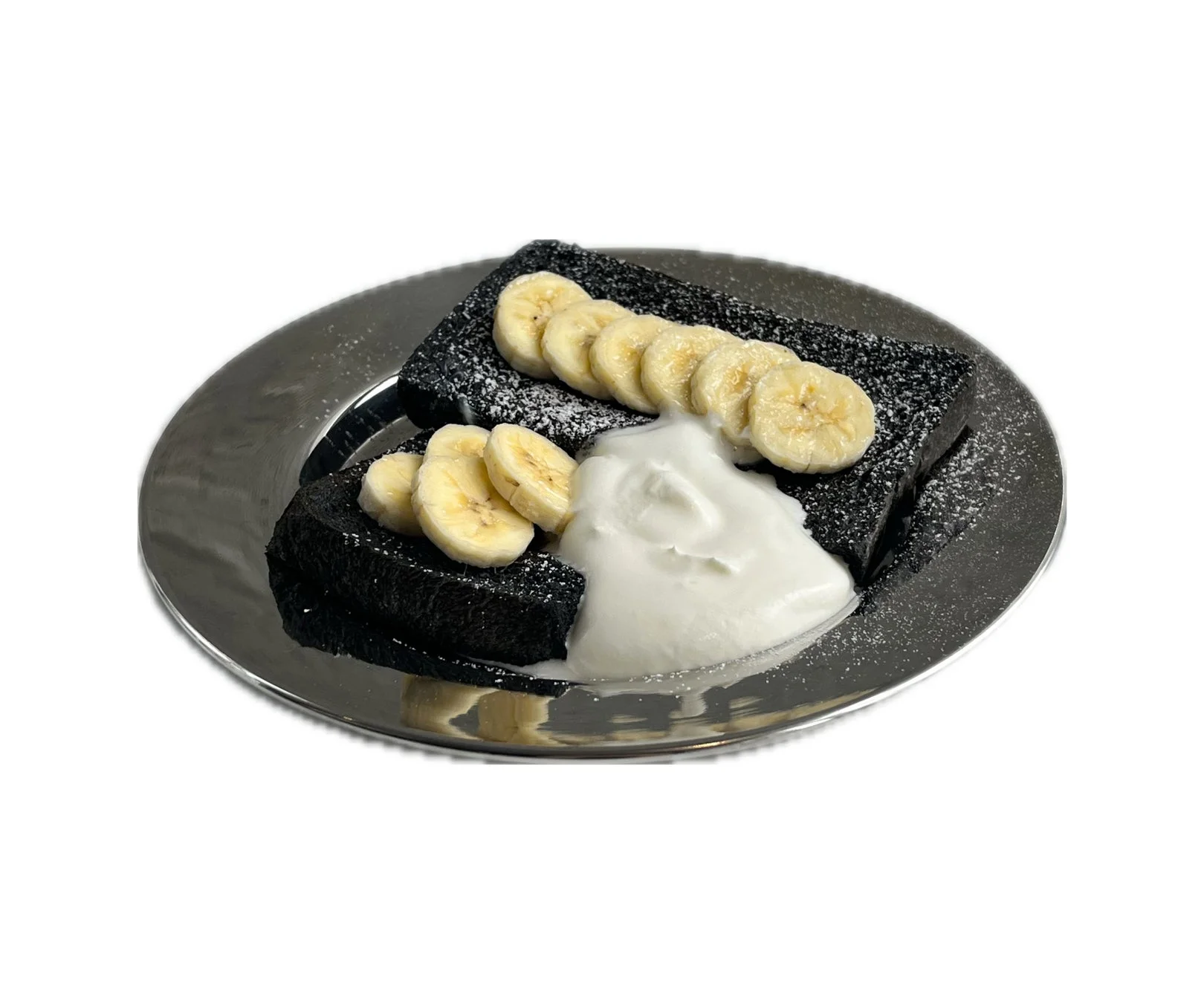 銀色の皿に盛られた黒いフレンチトーストです。バナナスライスと白いホイップクリームが添えられ、粉砂糖がまぶされています