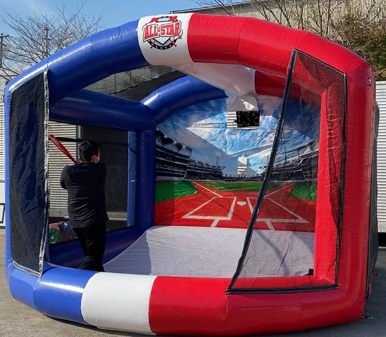 バッティングケージでバットを構える男性