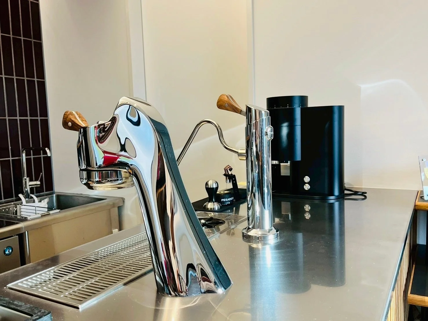 ステンレス製のカウンターに設置された、モダンなデザインのエスプレッソマシンとコーヒーグラインダー