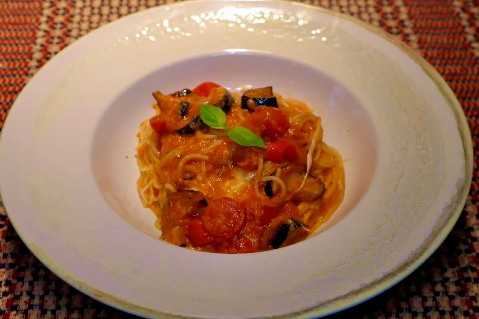白皿に盛られたナスとモッツァレラチーズのトマトソースパスタ