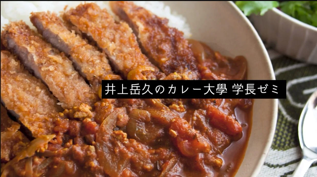 カツカレーのクローズアップ画像で、揚げたてのカツがご飯とカレーの上に盛り付けられています。