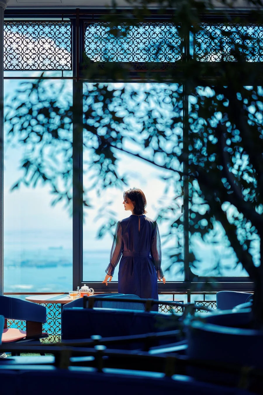 窓から海を眺める女性