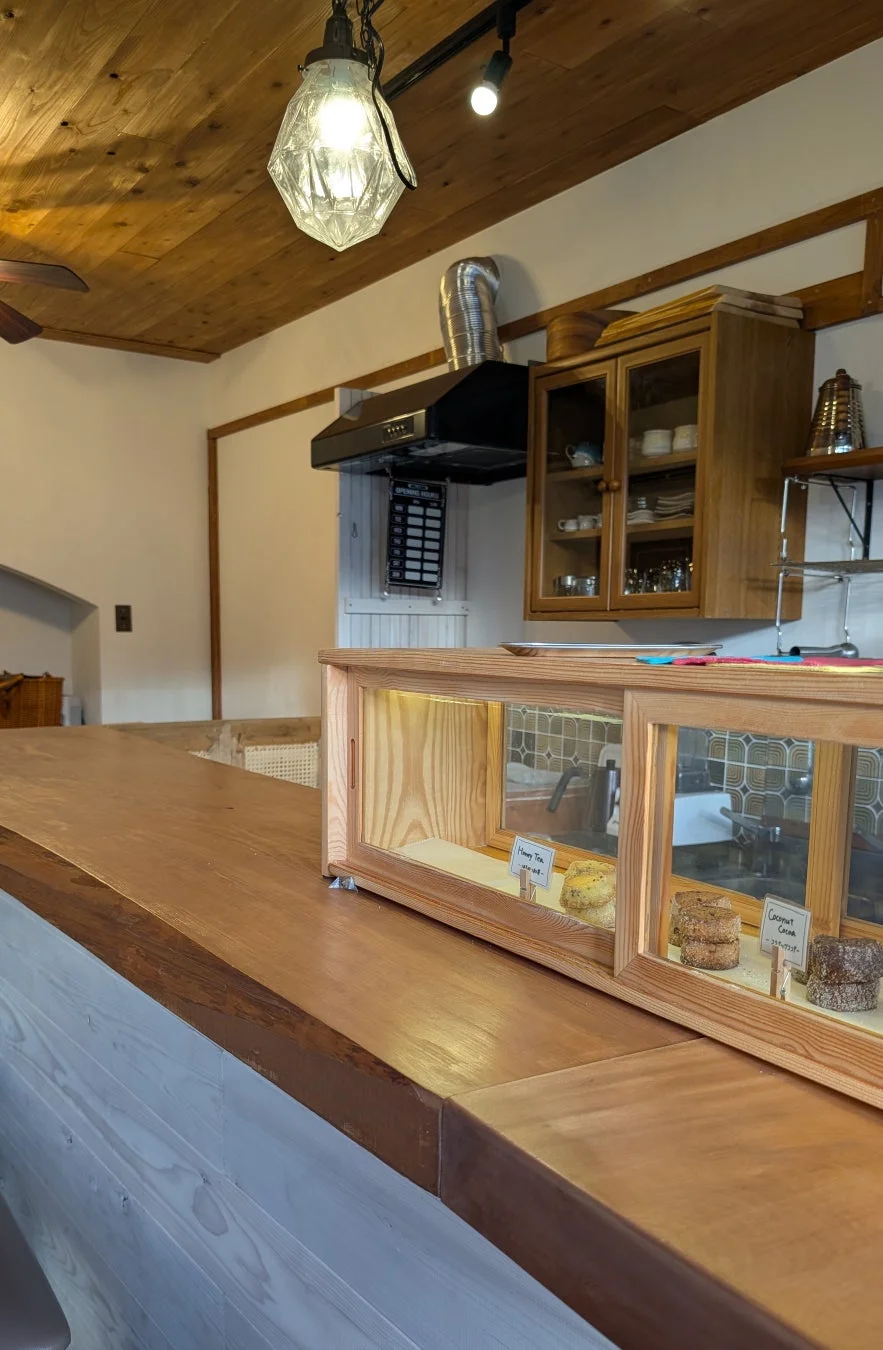 木製カウンターとスイーツのショーケースがあるカフェ店内