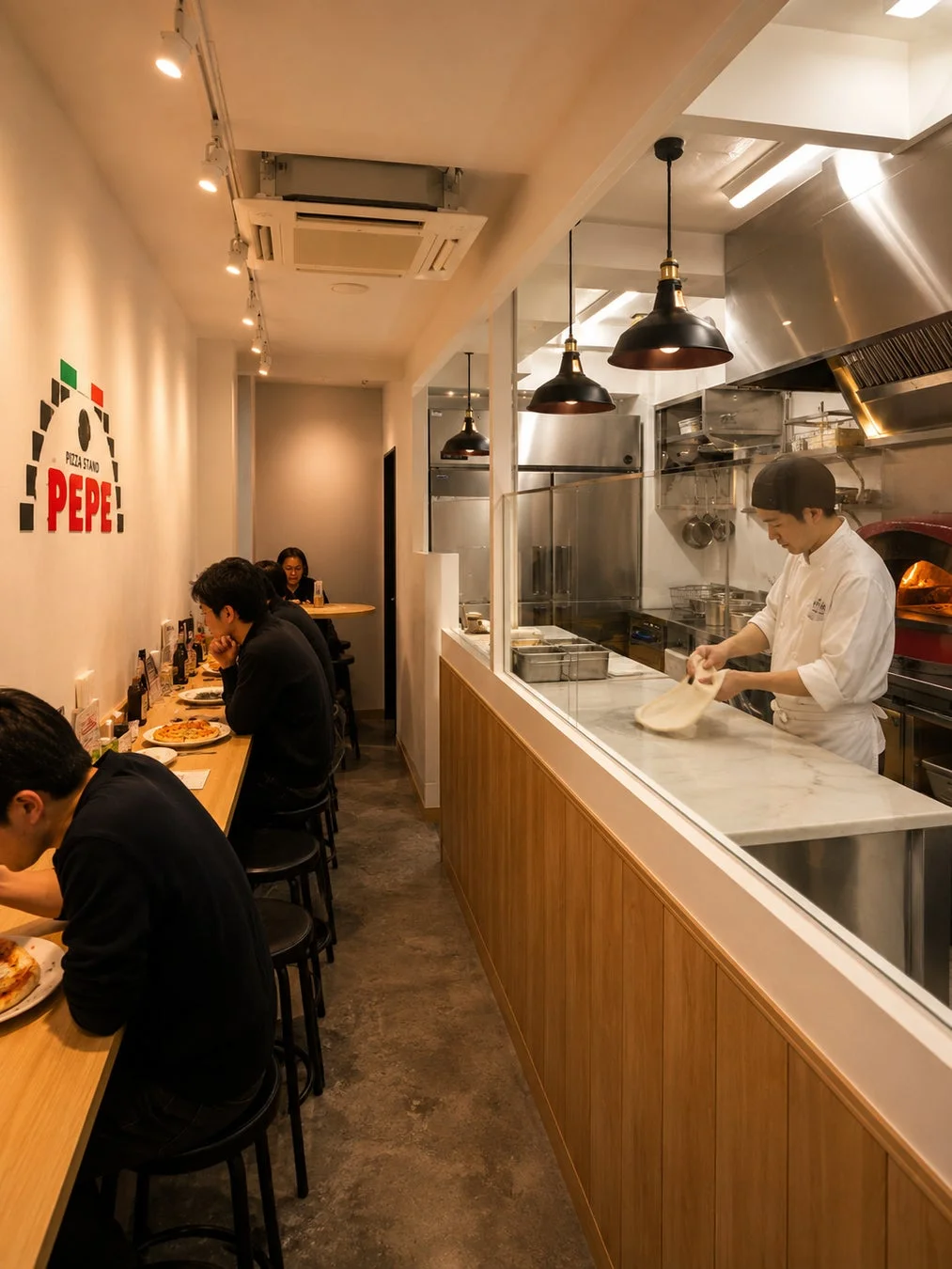 PIZZA STAND PEPE店内でシェフがピザ生地を伸ばしている様子