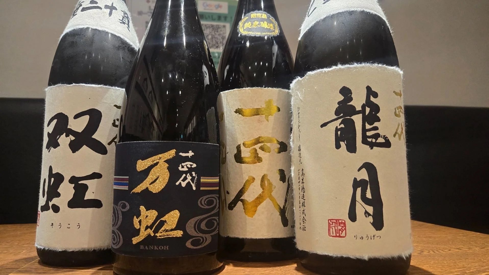 木製のテーブルに並べられた4本の日本酒ボトル