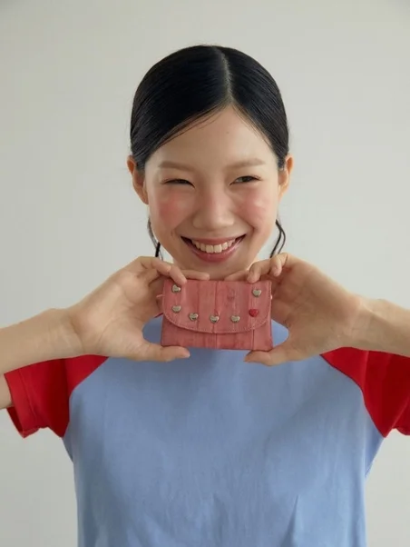 double quotesのピンクのウォレットを持つ女性