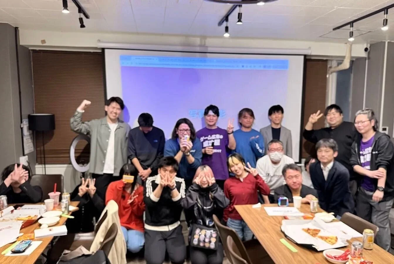 室内で人々が集まり、楽しそうにポーズを取っている集合写真