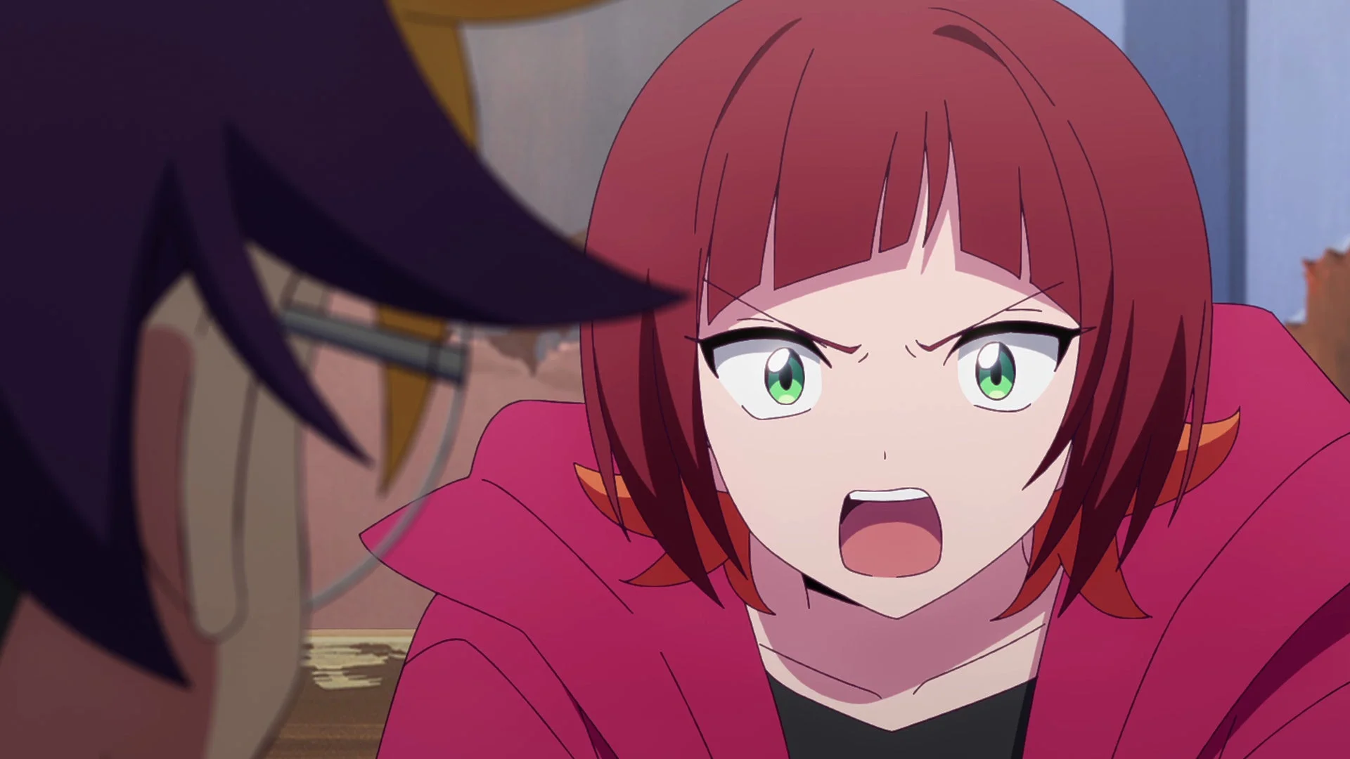 赤いショートヘアと緑色の目を持つアニメの少女が、怒った表情で何かを叫んでいるクローズアップ画像です。ピンクのパーカーを着ており、画面左には別のキャラクターの一部が見えます。