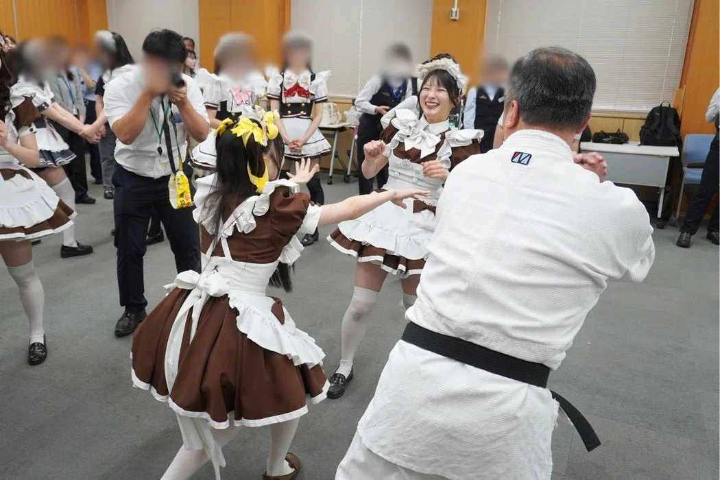 メイド服の女性と武道着姿の男性が交流