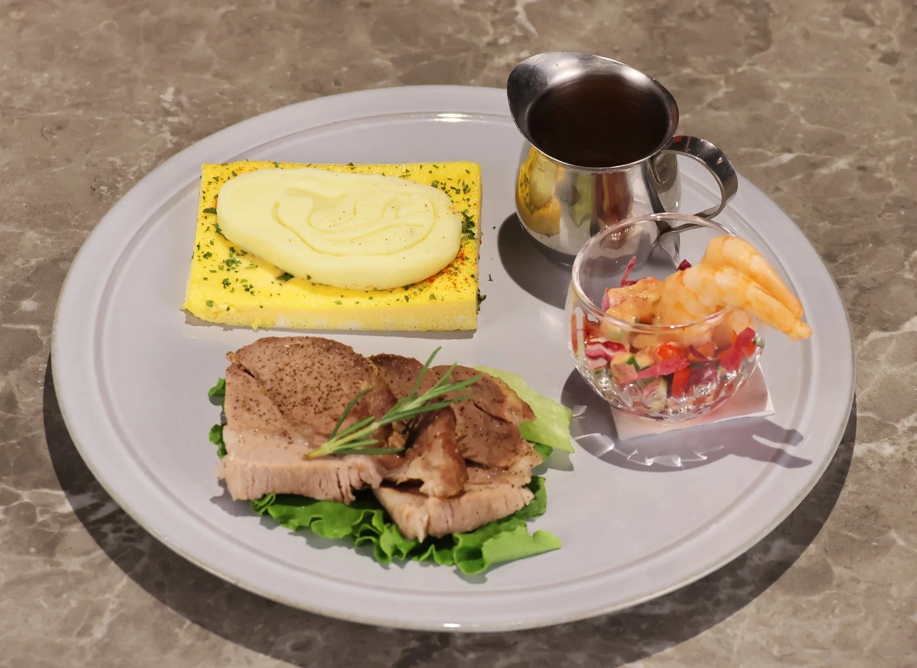 グレーのプレートに盛り付けられた洋風の食事